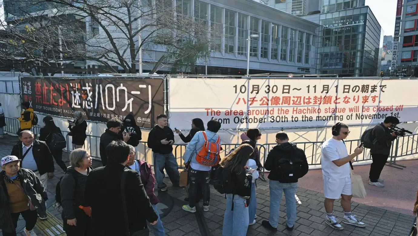 Zona de la estatua de Hachiko en Shibuya acordonada con vallas y un cartel en inglés