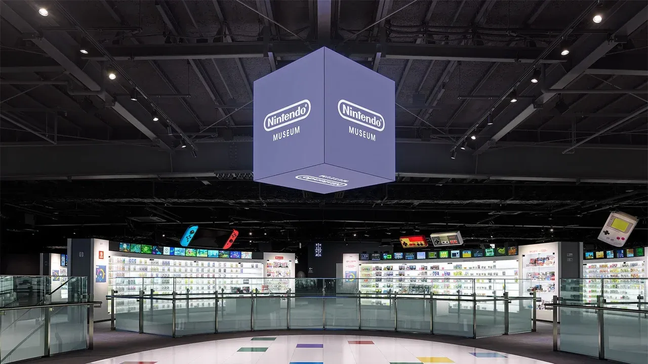 Interior del Nintendo Museum en Uji con vitrinas de consolas y el cubo central iluminado