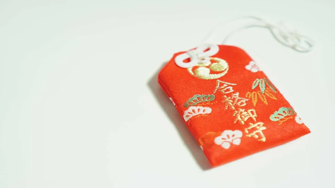 Omamori rojo japonés sobre fondo blanco, ejemplo de amuleto tradicional para explicar cómo hacer un omamori caser