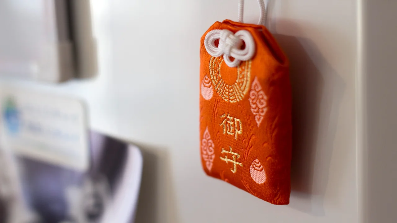 Omamori rojo japonés sobre fondo blanco, ejemplo de amuleto tradicional