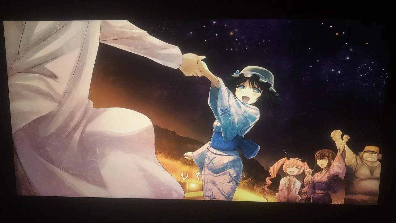 Escena de Steins;Gate en un festival de verano japonés: personaje femenino en yukata azul tomando la mano de otro personaje bajo un cielo estrellado