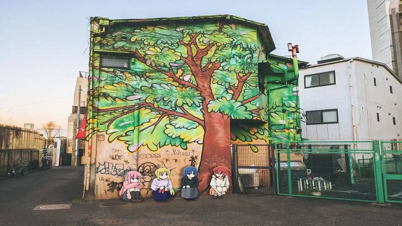Mural callejero con un árbol gigante en Shimokitazawa junto a las protagonistas de Bocchi the Rock!