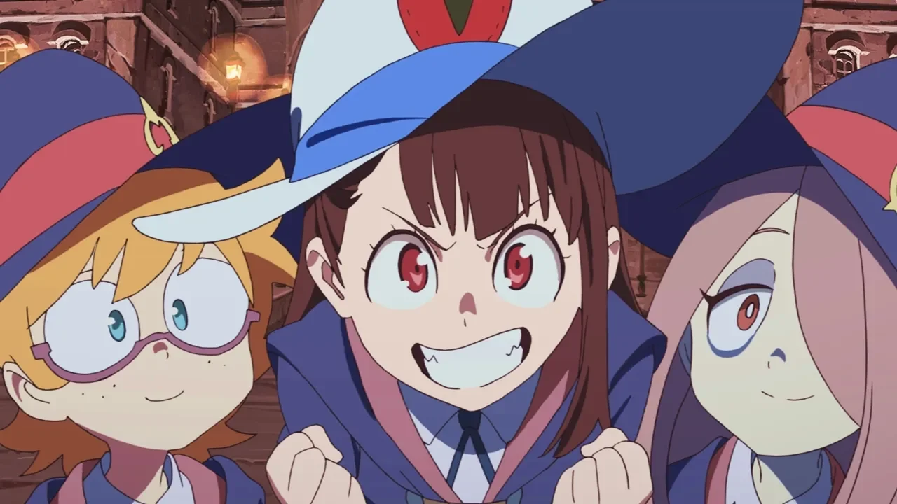 Akko Kagari, protagonista de Little Witch Academia, con expresión decidida y los puños apretados, flanqueada por sus compañeras Lotte y Sucy en el pasillo de la academia Luna Nova