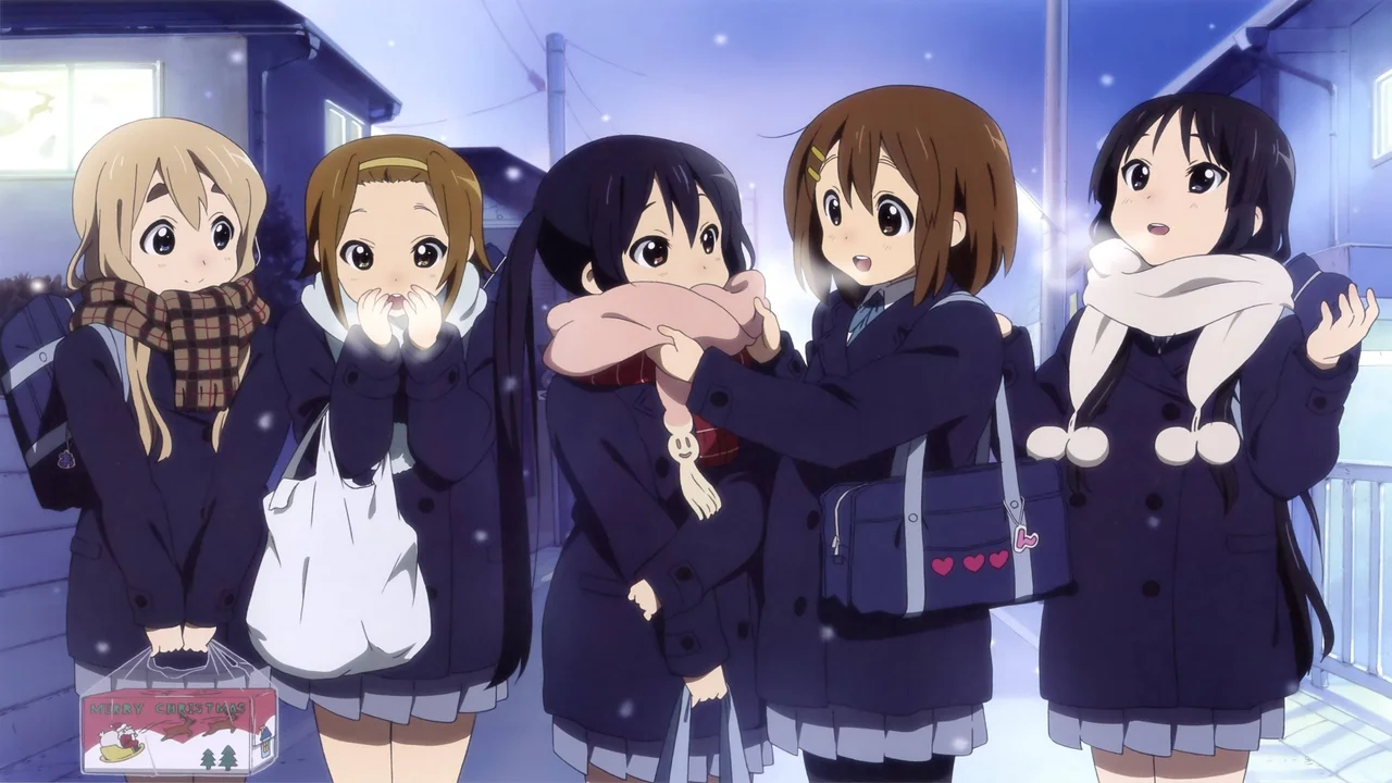 Cinco chicas de K-On! con abrigos de invierno y bufandas bajo la nieve, ejemplo perfecto de estética moe en el anime