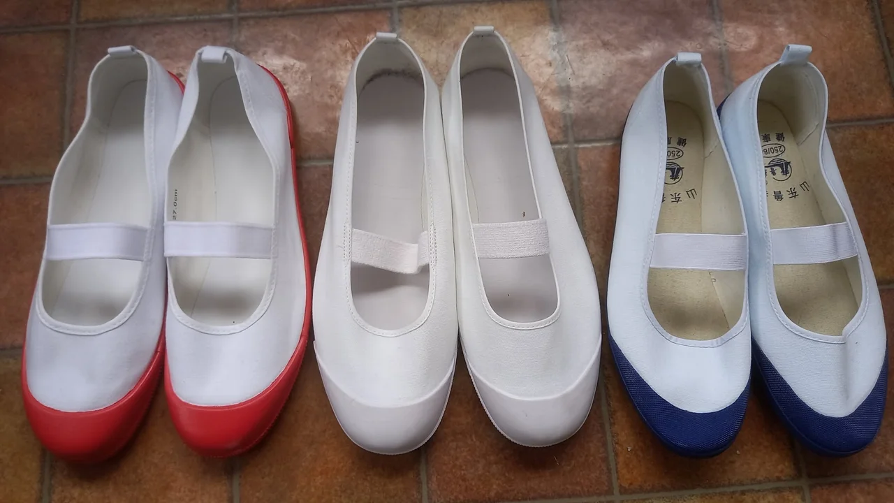 Tres uwabaki reales con franjas de colores azul, rojo y blanco que indican el año escolar del alumno en los institutos japoneses