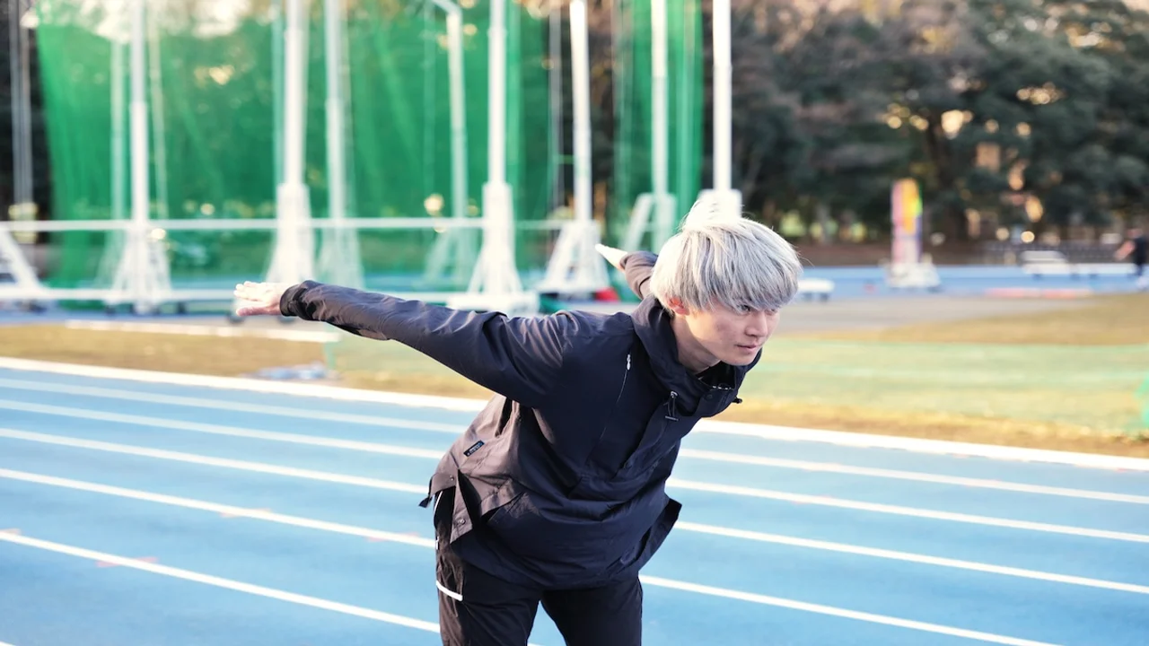 Corredor real en una pista de atletismo imitando la postura de carrera de Naruto con los brazos hacia atrás