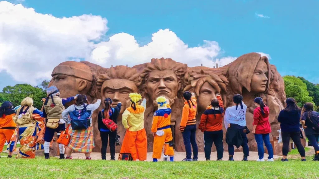 Visitantes disfrazados frente al mural de los Hokage en Nijigen no Mori, parque temático de anime en Awaji, Japón