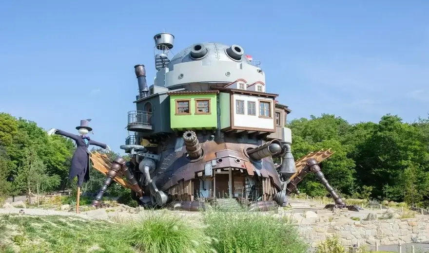 Castillo Ambulante de Howl a tamaño real en Ghibli Park, con patas mecánicas, chimeneas y el espantapájaros Calcifer al lado