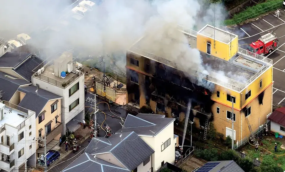 Incendio provocado en el estudio Kyoto Animation en Japón, con bomberos y humo saliendo del edificio amarillo en 2019
