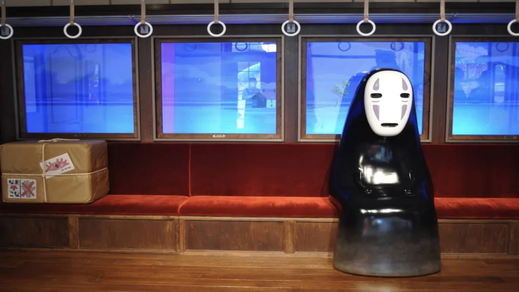 Figura de Sin Cara sentada en el vagón de tren de la exposición de El Viaje de Chihiro en el Museo Ghibli