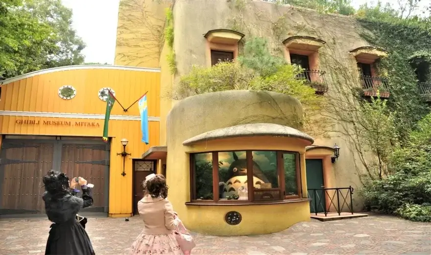 Fachada del Museo Ghibli de Mitaka con la ventana redonda de Totoro y visitantes haciendo fotos frente a la entrada